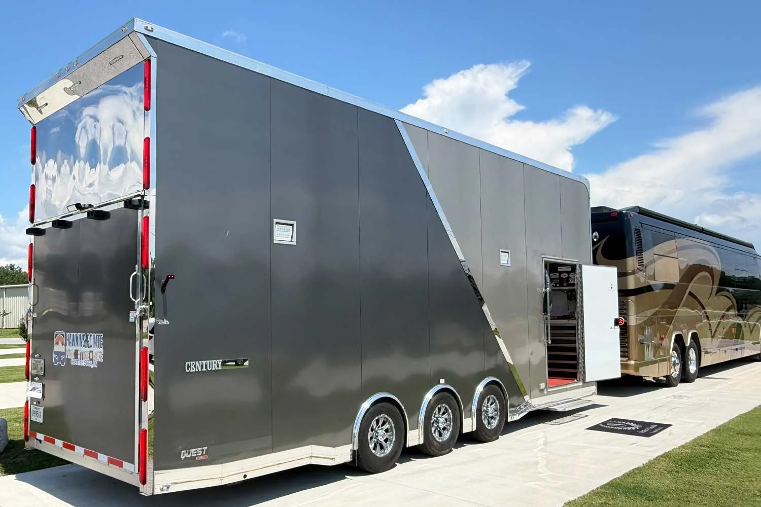 Rear passenger-side view of the trailer beside a motorcoach