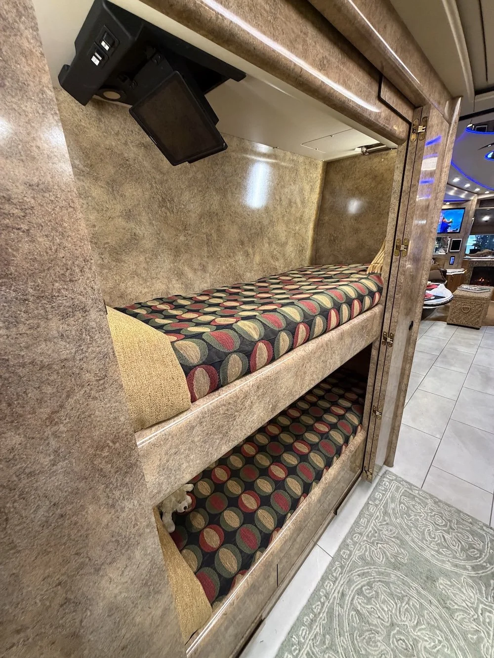 Bunk bed view with living area in background.
