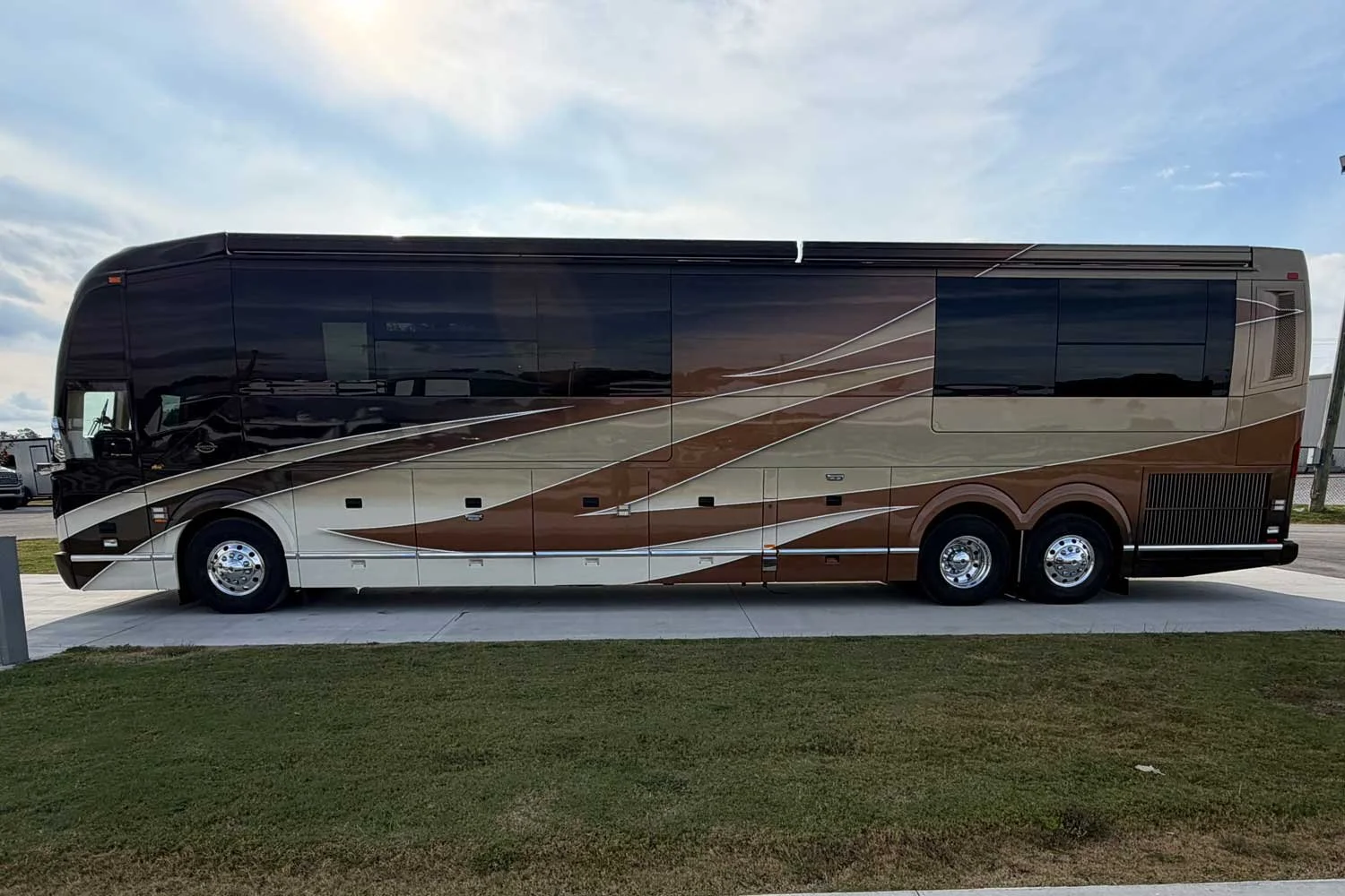 Driver-side view of the coach parked on a concrete pad.