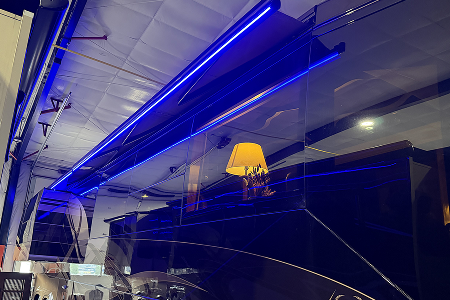 Luxury motorcoach at night with full-length blue LED Awning GLO illumination.