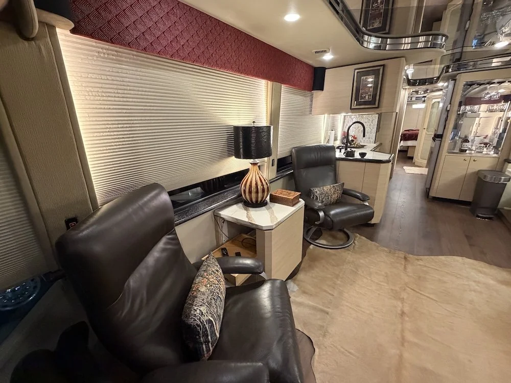 Salon seating with recliner, side table, and lamp.
