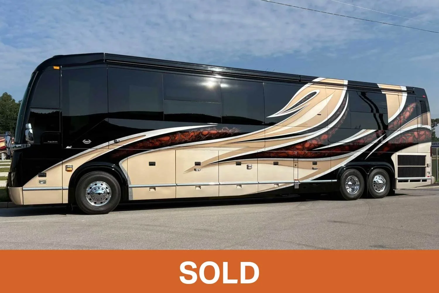 Prevost Marathon under a bright blue sky on pavement.