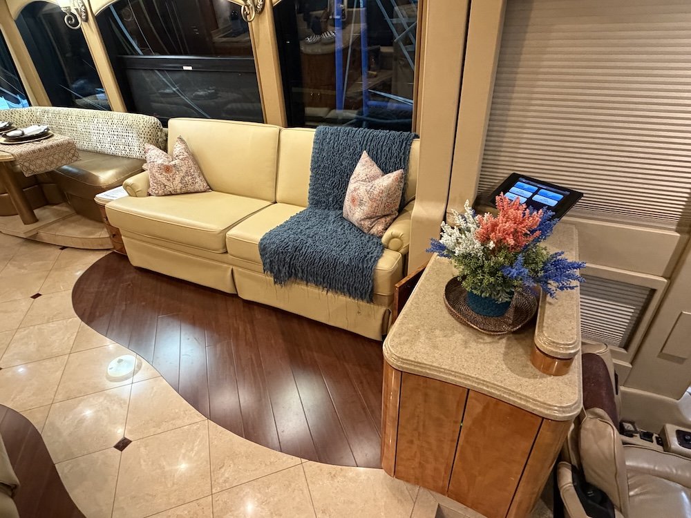 Living area featuring a light-colored fabric sofa and curved wood flooring.