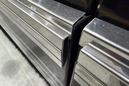 Close-up of polished stainless steel rub rails.