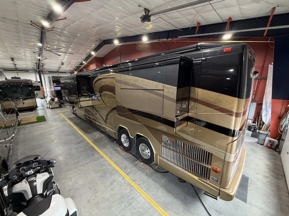 High-angle rear view of a double-slide Prevost coach indoors.
