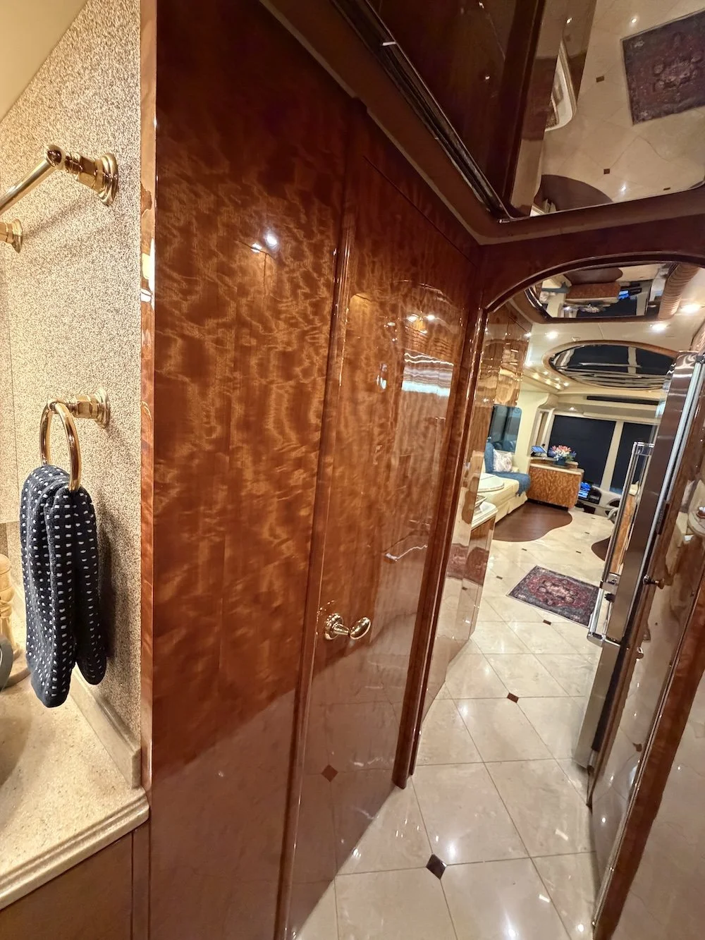 High-gloss wood closet doors in the hallway leading to the bedroom.