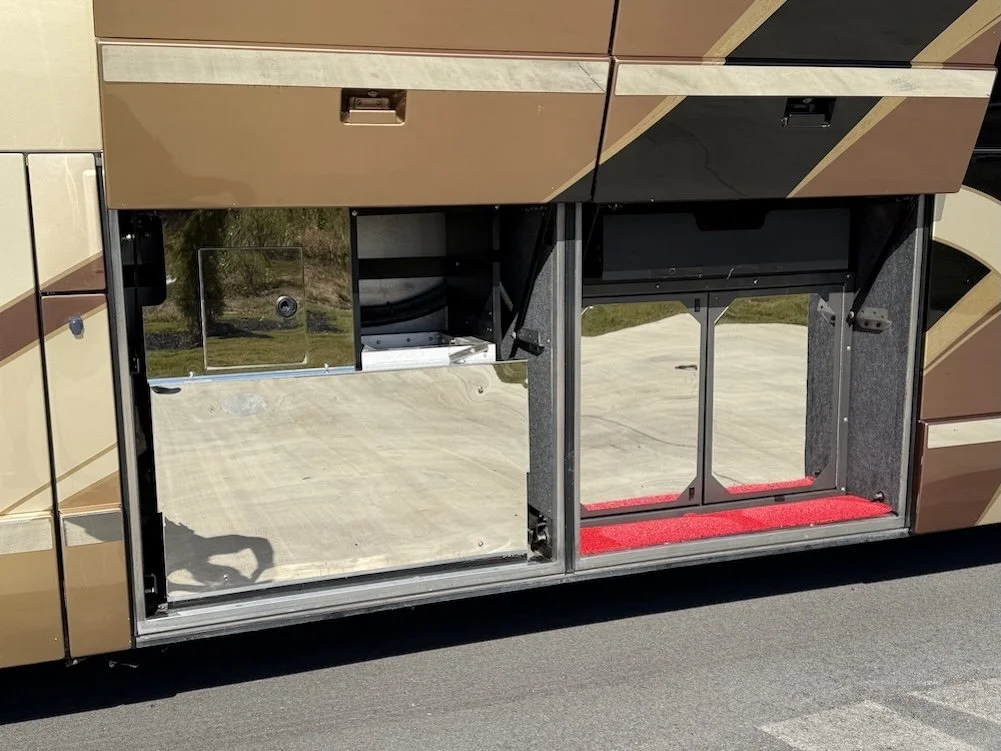 Empty pass-through under-coach storage bay with doors open.