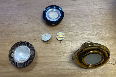 Comparison of outdated gold and black halogen-style light fixtures and loose LED chips.