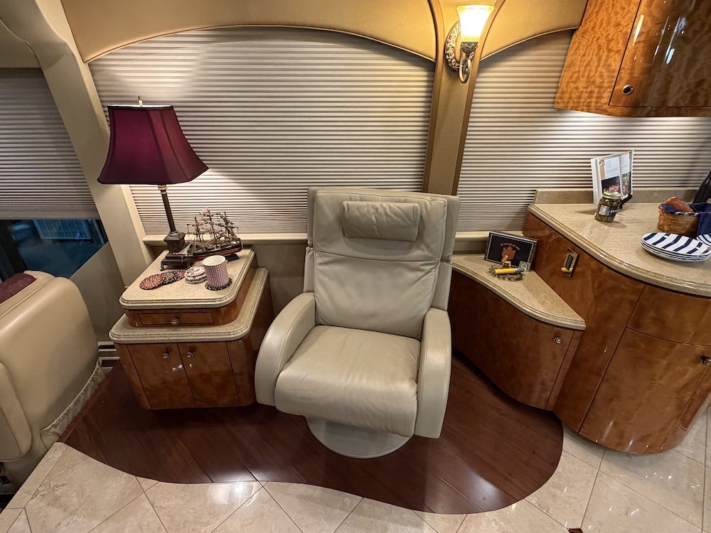 Cozy salon seating area with a leather recliner, side table, and lamp.