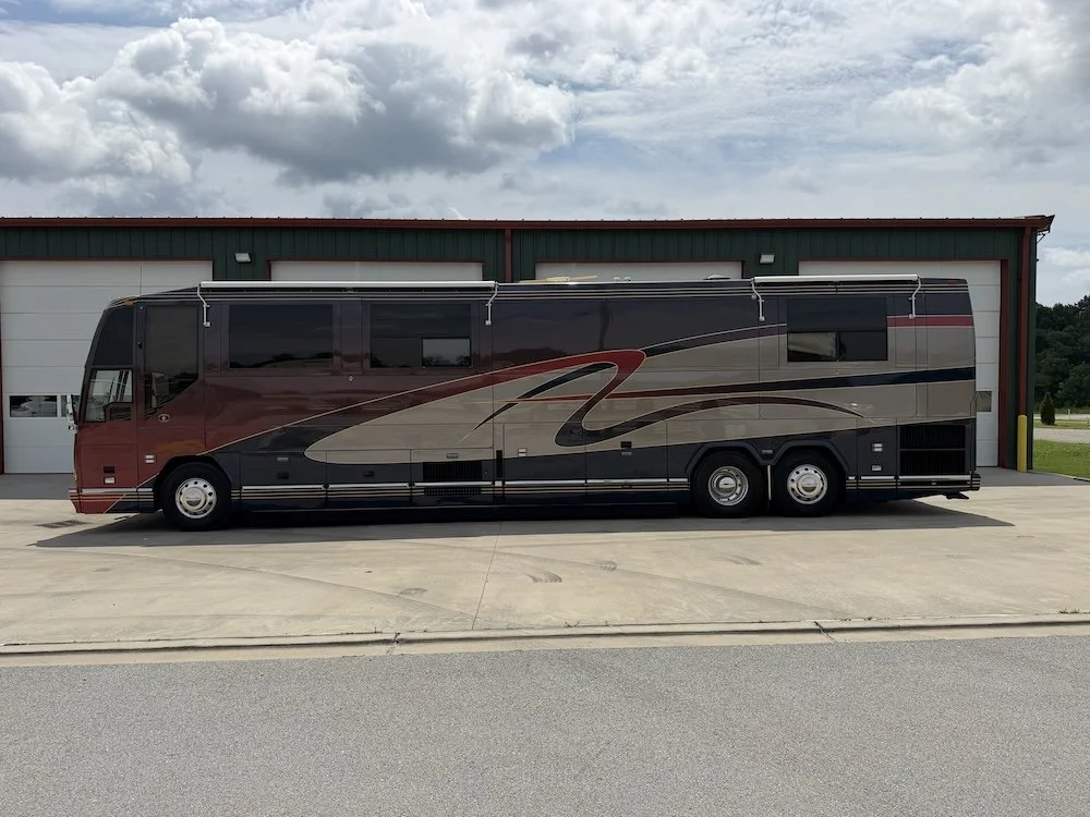 Driver-side view of the Prevost H3-45 parked outside.