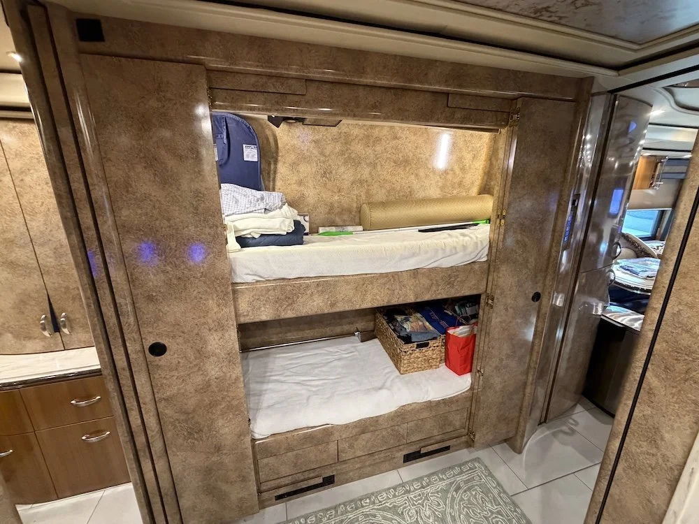 Luxury bunk bed configuration with integrated lighting and stone-finish cabinetry.