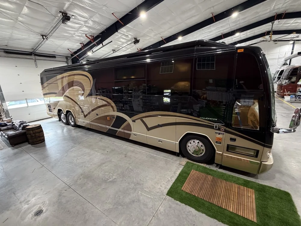High-angle passenger side of a black and gold luxury coach.