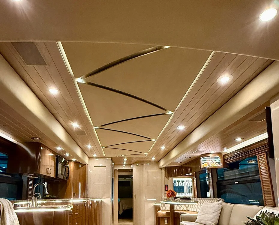 Motorcoach salon featuring warm 3000K Mirage Series ceiling lights and cabinet accents.
