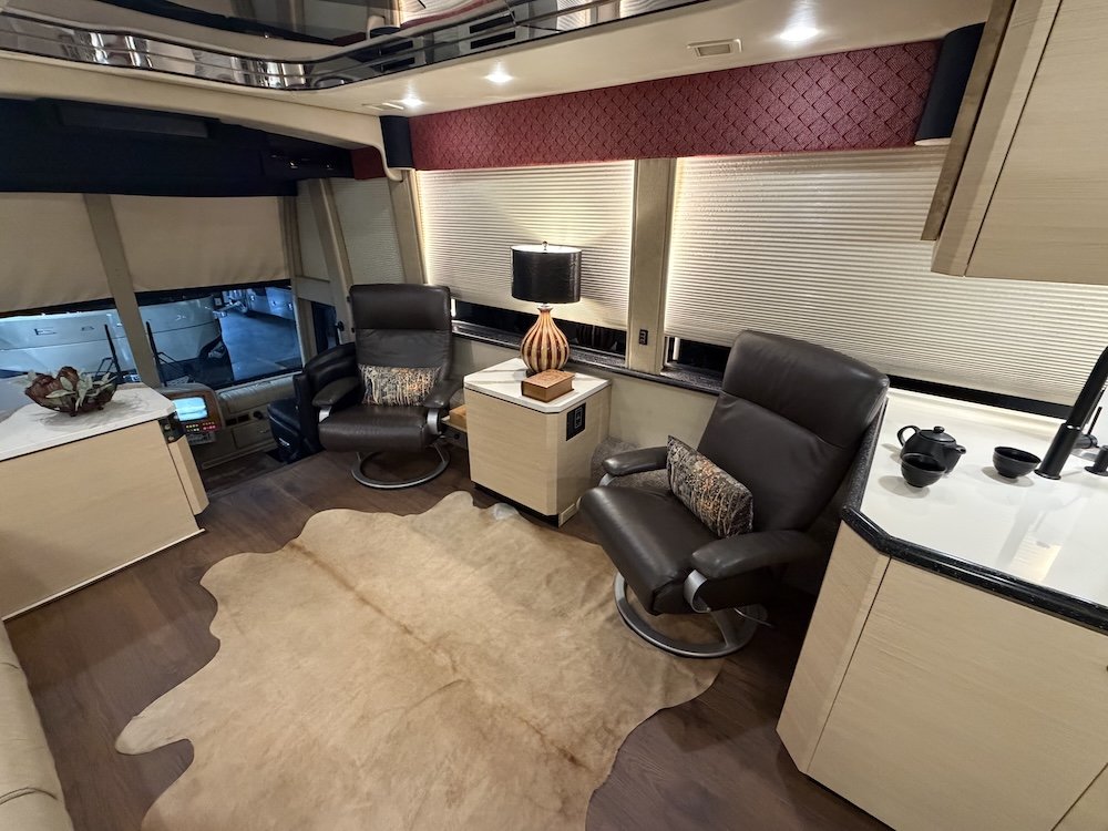 Salon with leather recliners, cow hide rug, and TV.
