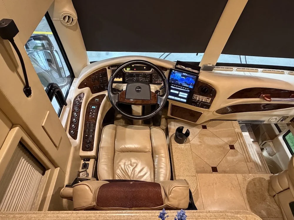 Overhead view of the driver cockpit, dashboard controls, and leather steering wheel.