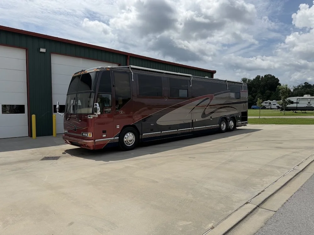 Front driver-side view of the 2002 Prevost Featherlite H3-45 in burgundy and silver.