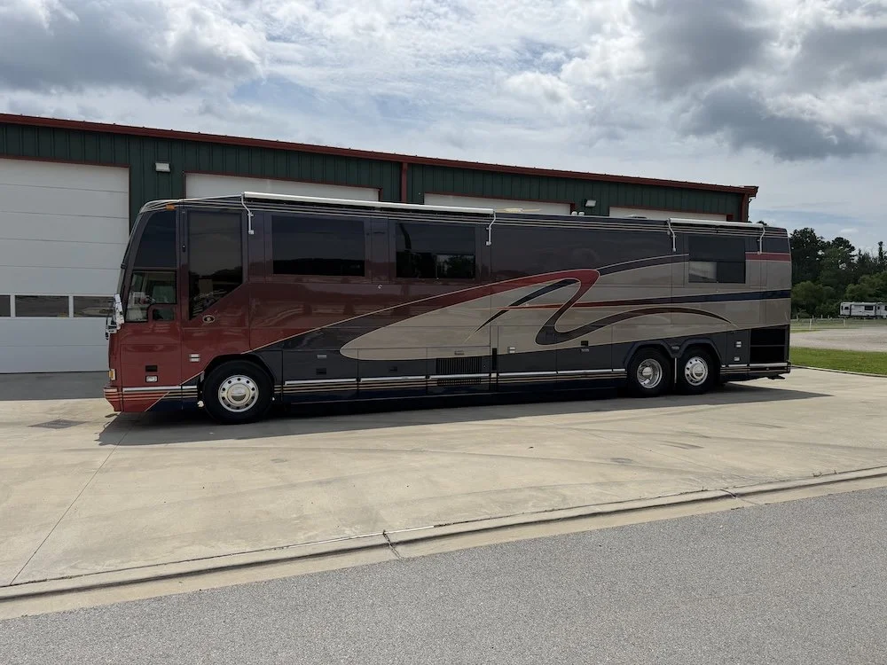 Driver-side view of the coach parked outside.
