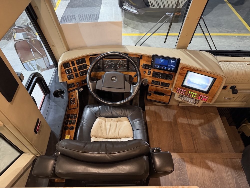 Cockpit view with steering wheel, dash, and driver seat.