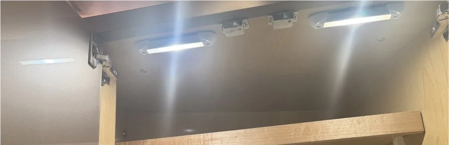 wo ultra-slim LED Mini Rails mounted to the ceiling of a storage cabinet.