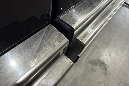 Side profile view showcasing the flush, mirror-finish stainless steel rub rail.