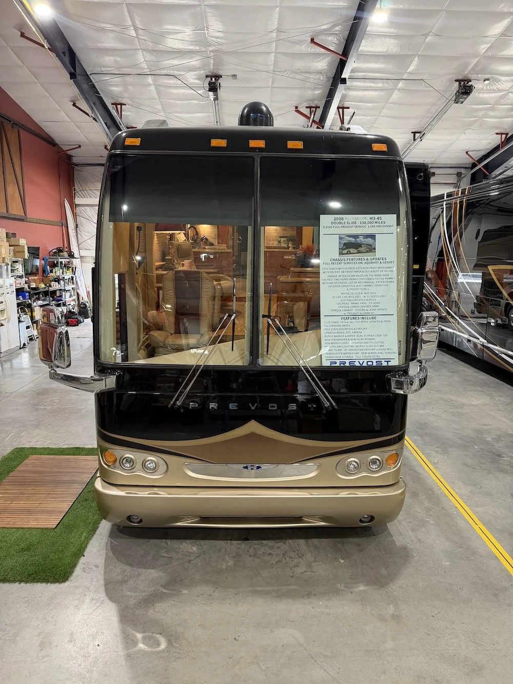 Head-on front view of a black and gold Prevost Millennium coach.