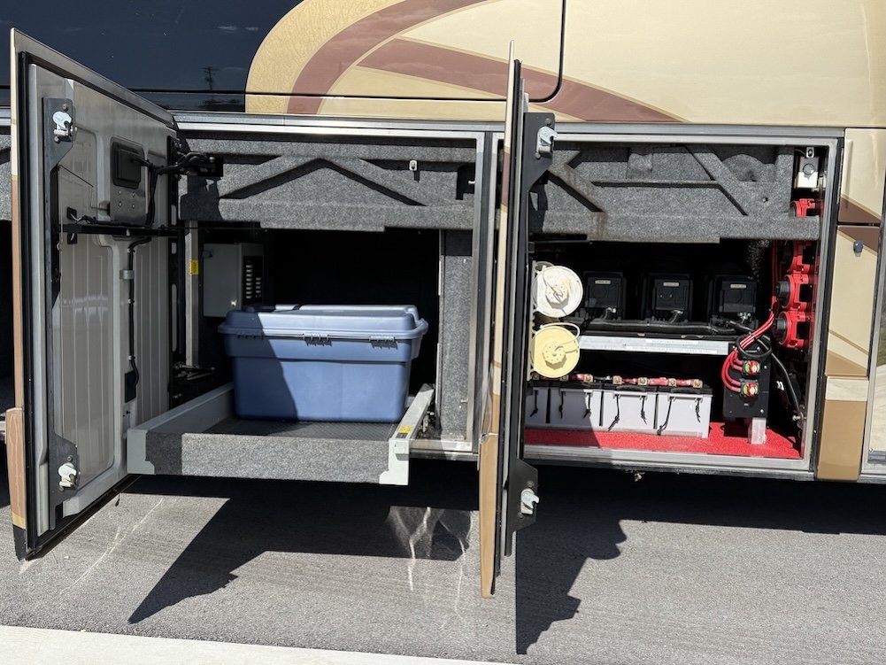 Open storage bay featuring a slide-out tray and battery compartment.