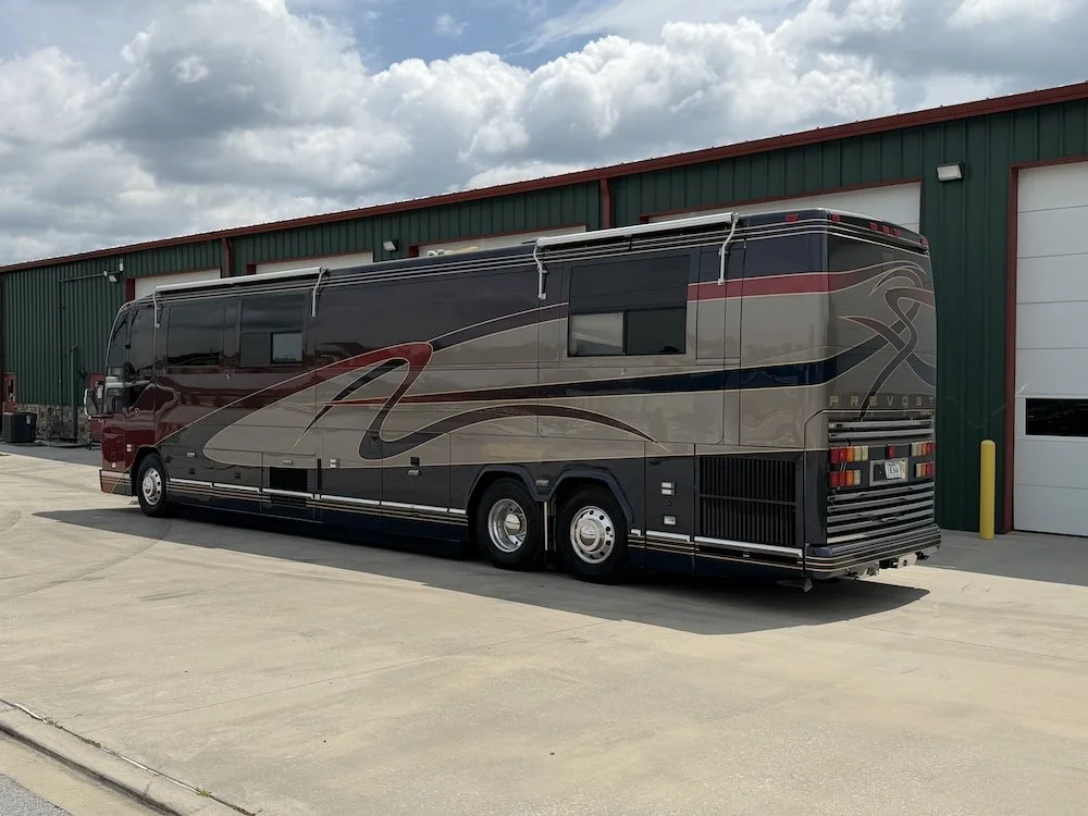 Rear passenger-side view of the coach outdoors.