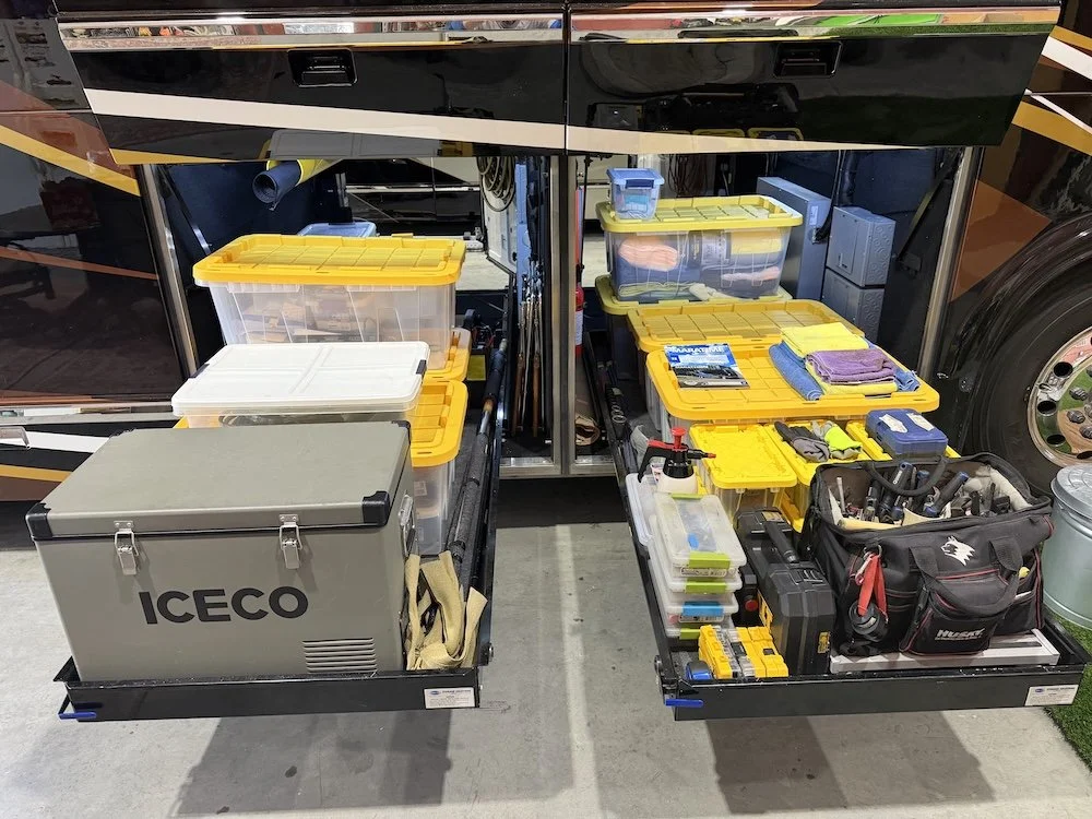 Tools and storage containers organized inside the compartments of a luxury RV.