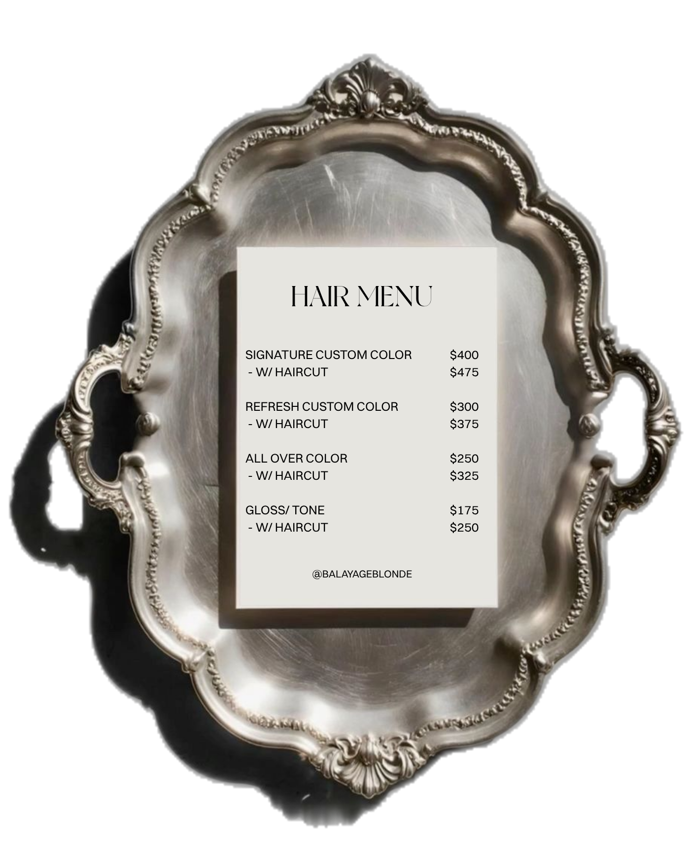 A hair salon price list displayed on a white sheet of paper, placed in an ornate silver frame, on a black background. The menu includes prices for various hair coloring and haircut services with options for different color and haircut combinations.