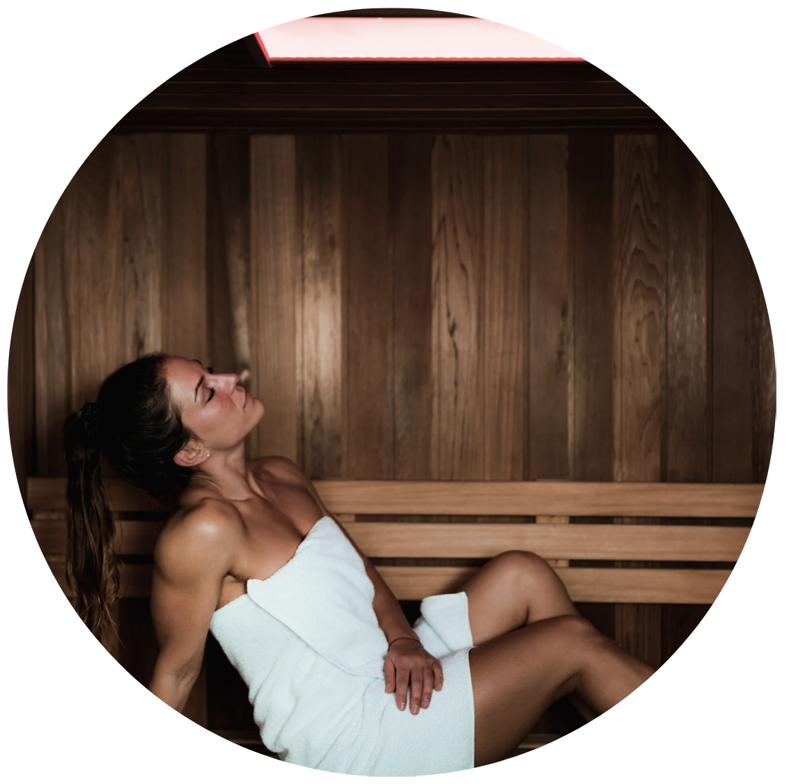 A woman enjoying a  sauna membership for warmth, recovery, and nervous system support at Recouia Spa and Holistic Wellness located at 16108 Ash Way Suite 111, Lynnwood, WA 98087