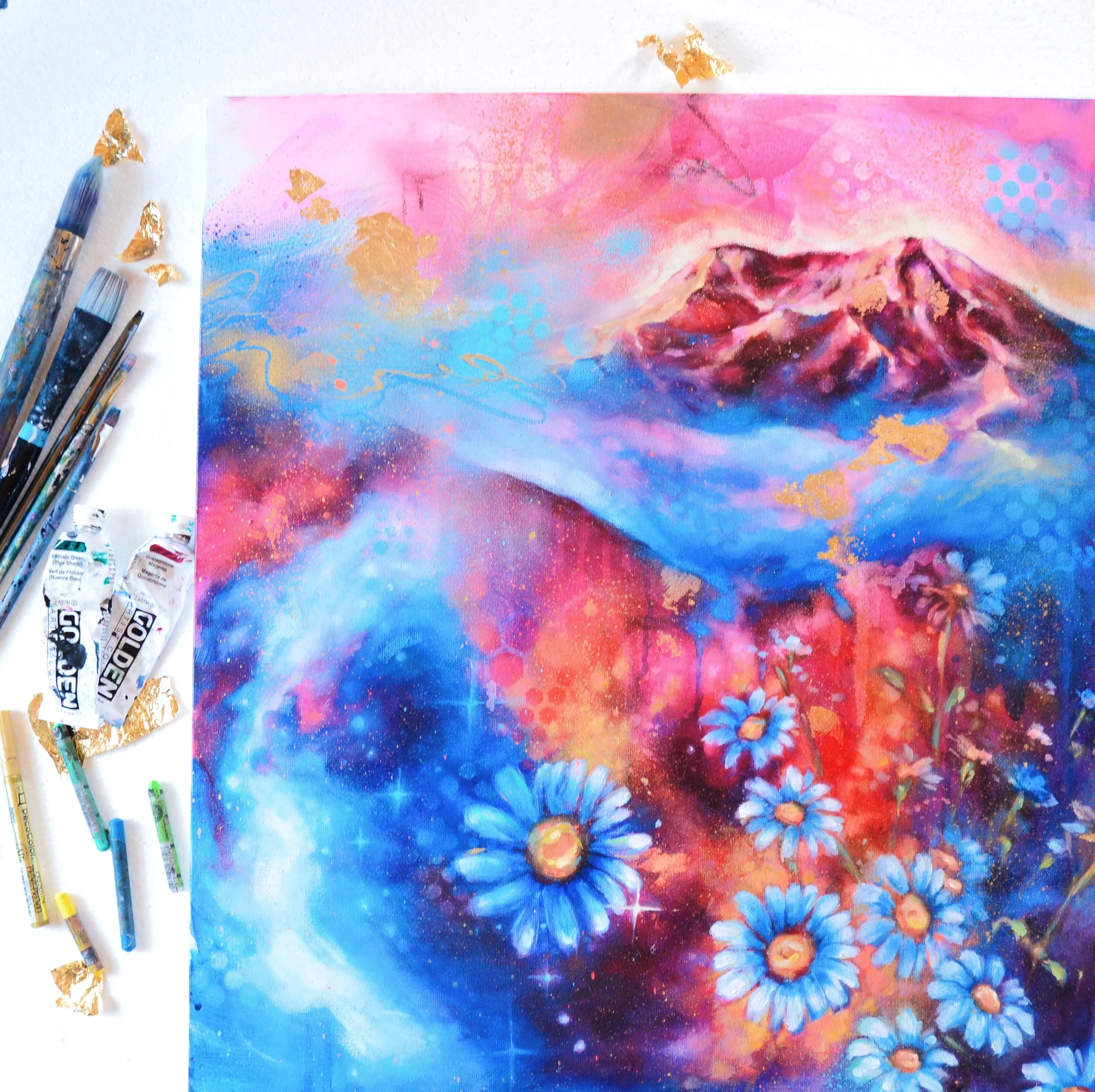 A colorful painting of a cosmic landscape with mountains, a galaxy, and blue daisies. Art supplies like brushes and paint tubes are on the left side.