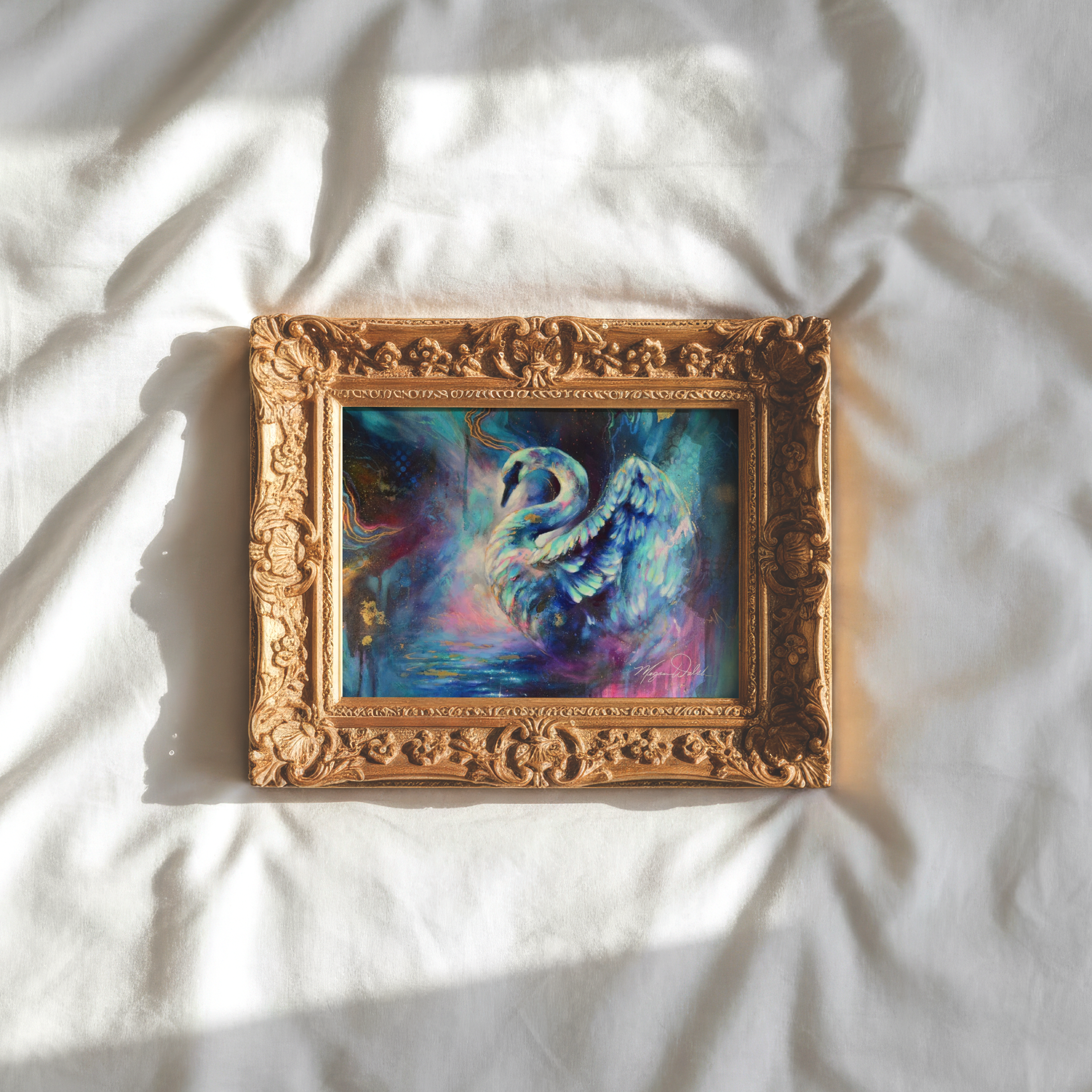 Close-up of a painting with a decorative gold frame, depicting two swans intertwined in a colorful, abstract style.