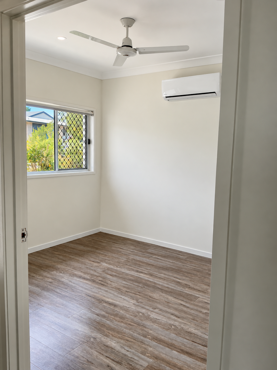 Bright Empty Room with Window and Fan.png