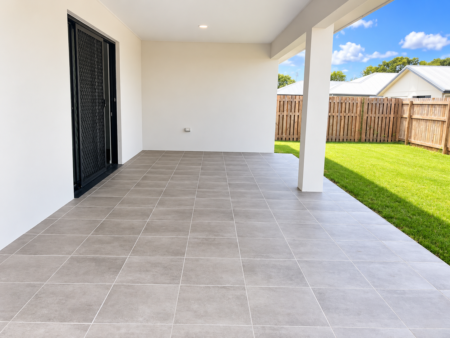 Modern Covered Patio Overlooking Green Backyard.png