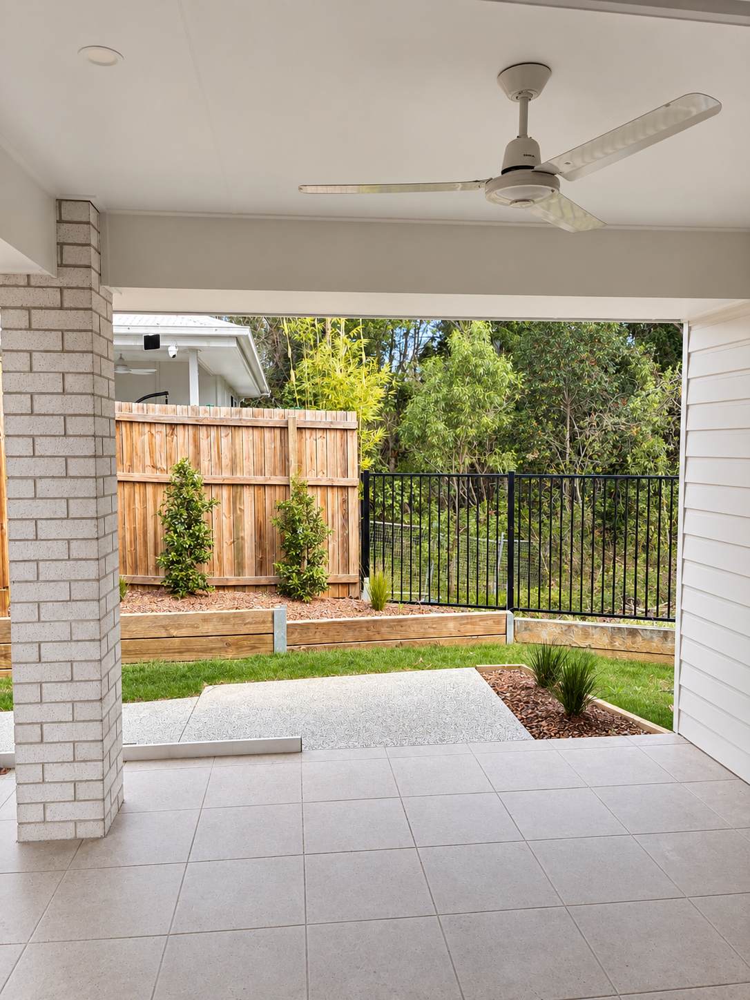 Bright Covered Patio Overlooking Landscaped Backyard.png