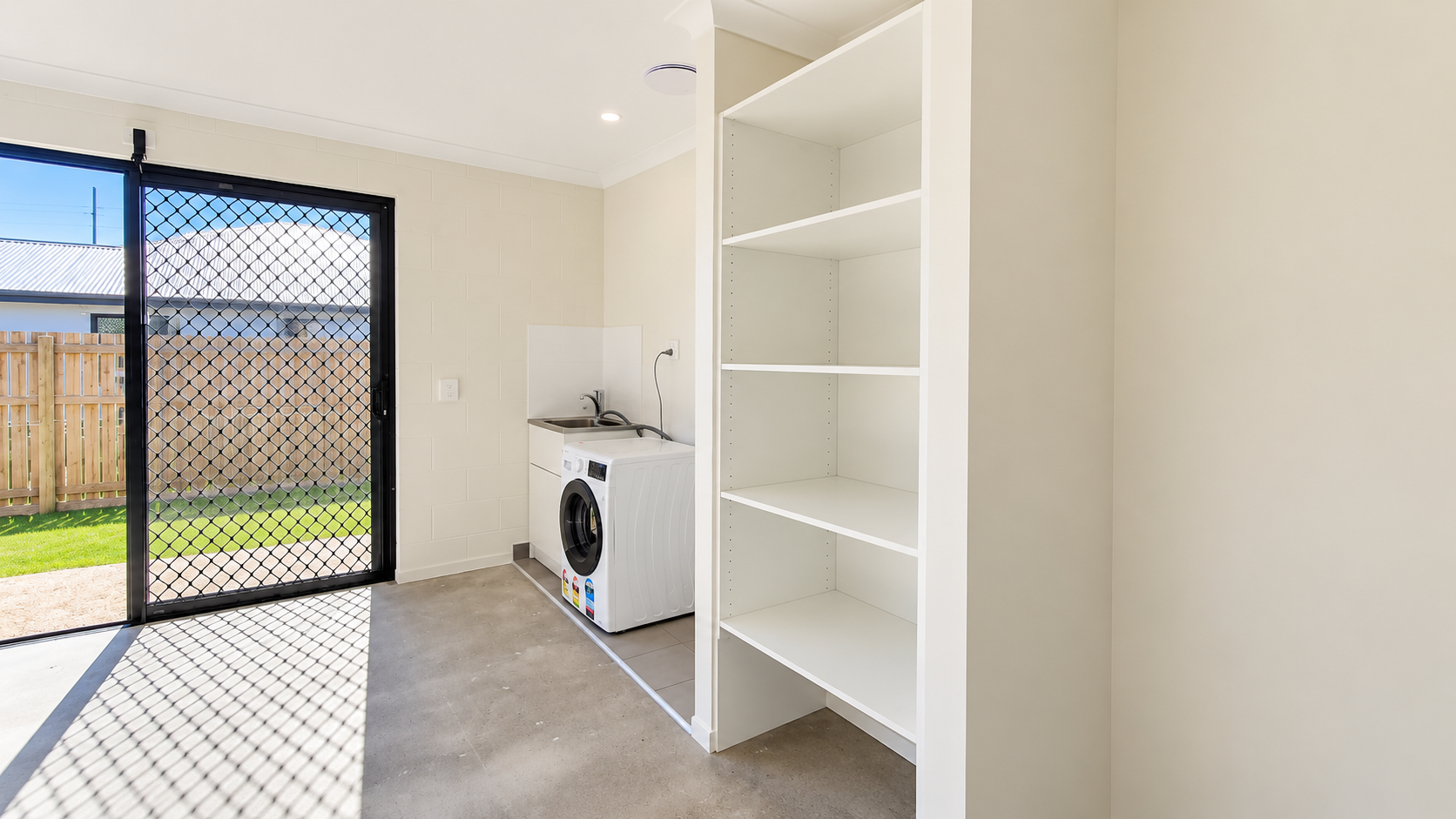 Bright Minimalist Laundry Corner with Sunlit Diamond Shadows.png