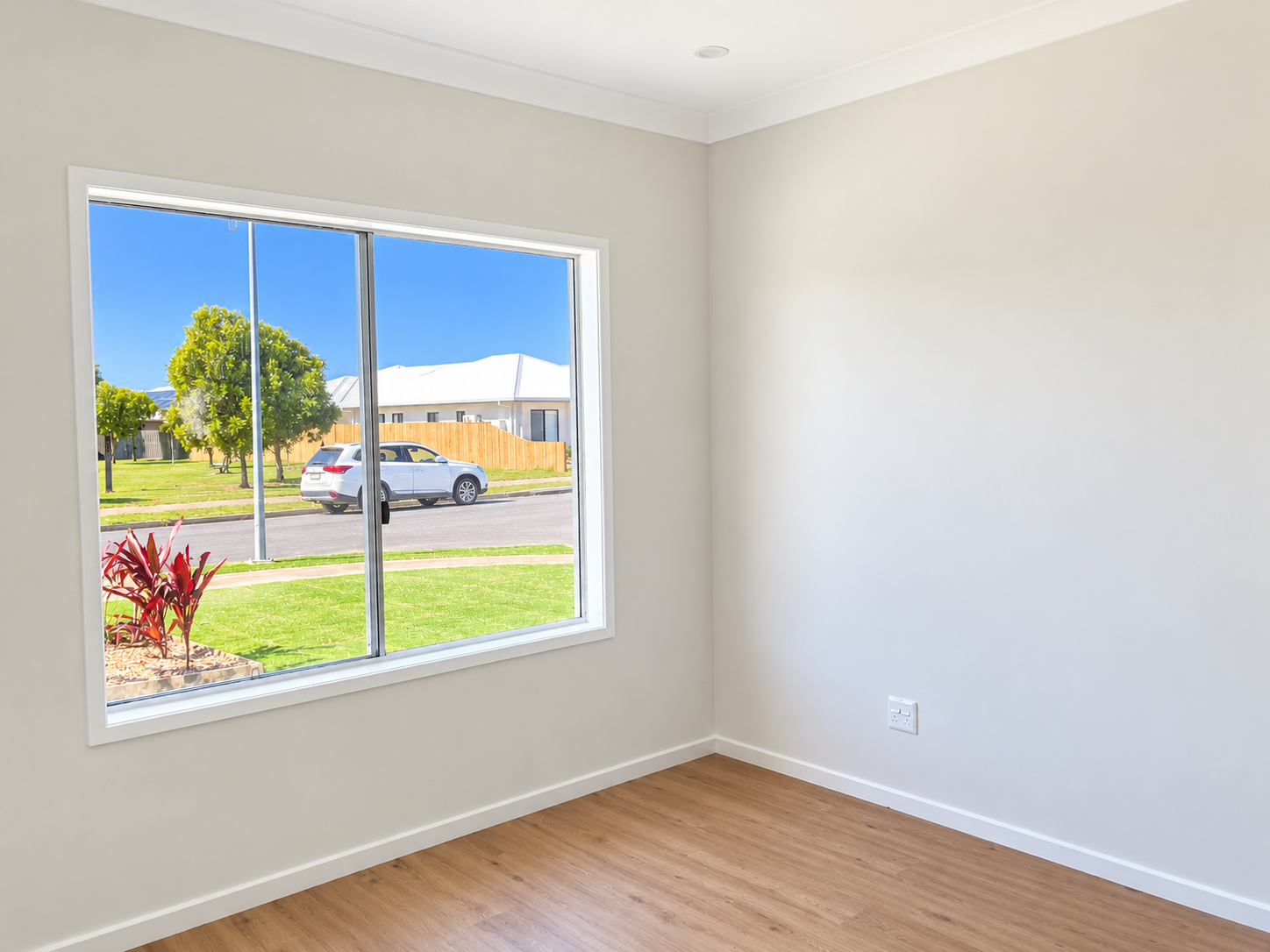 Sunlit Empty Room with Suburban Window View.png