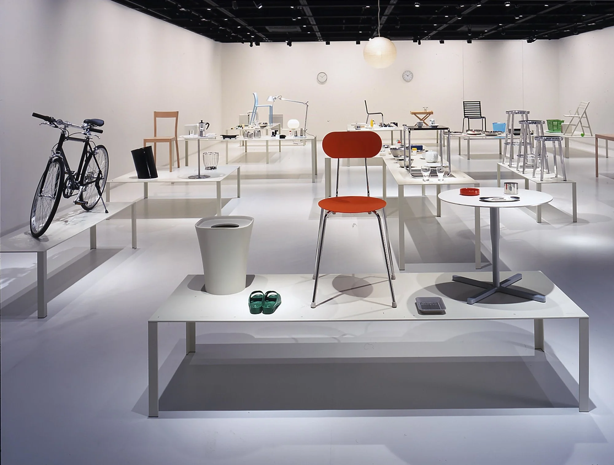 Photograph of an exhibition showcasing 'normal' things like a chair, a bike, tables and more