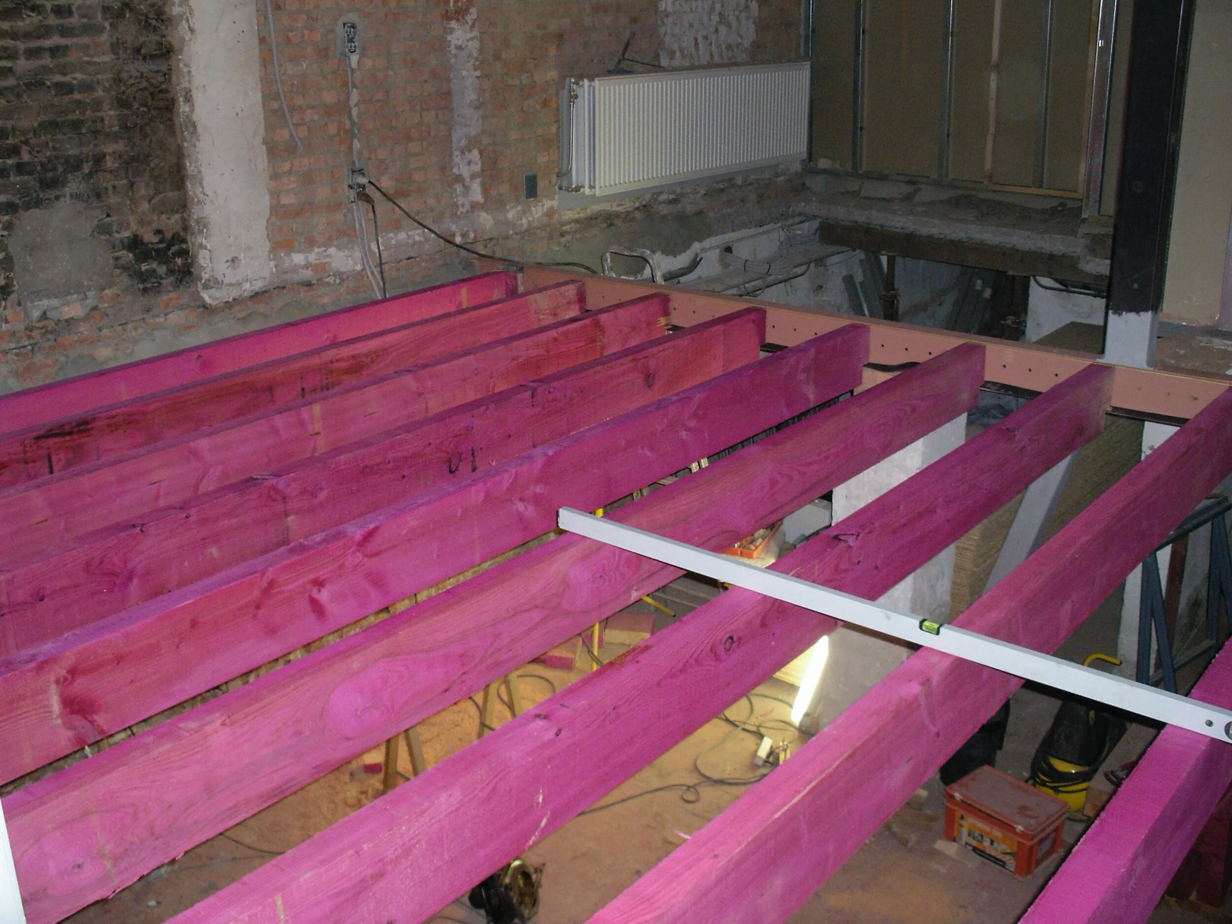 Plaatsen van nieuwe houten balkenlaag. Behandeld met boorzouten als bescherming tegen mogelijk ongedierte