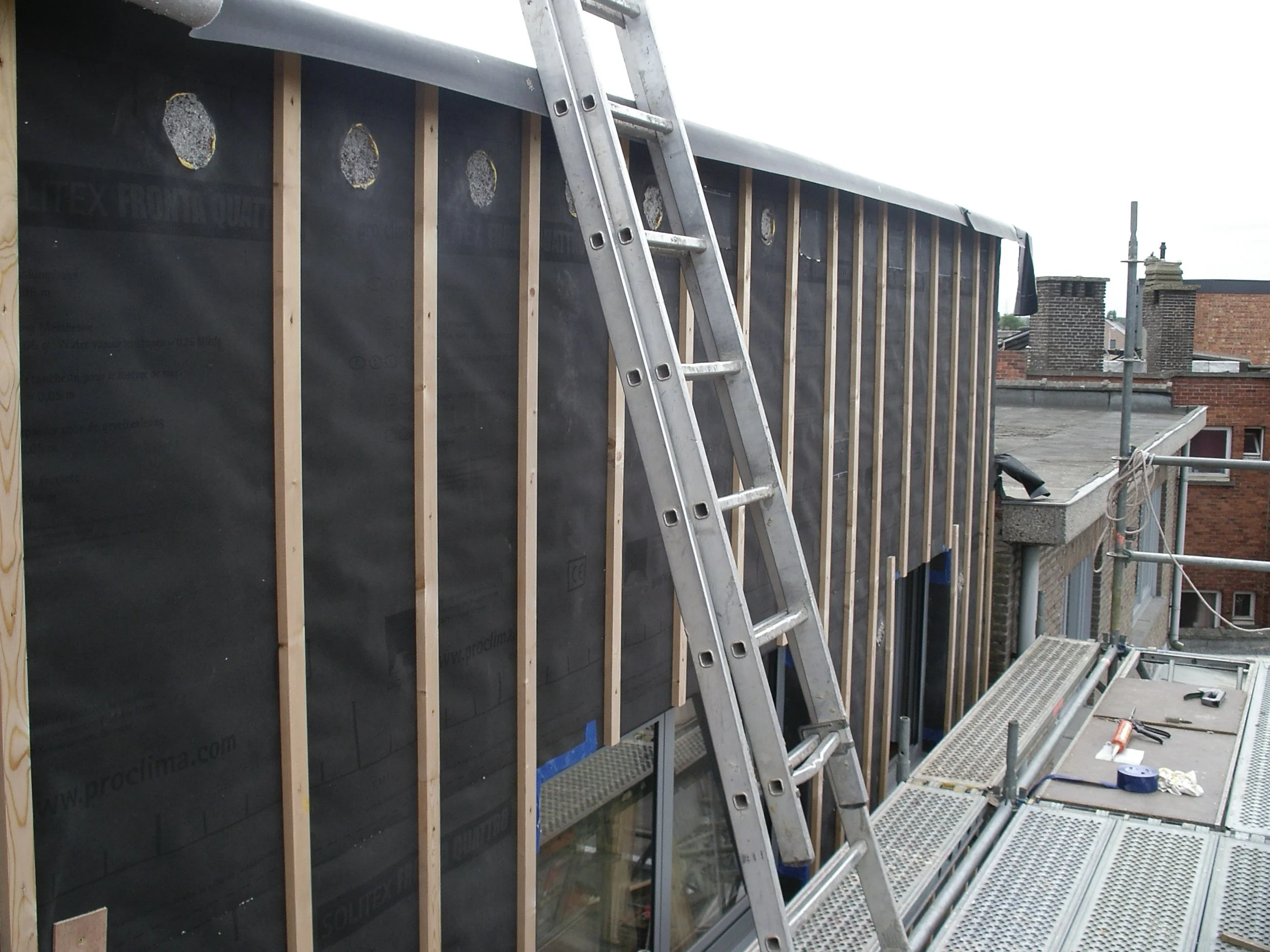 Voorbereding ondergrond. We gebruiken een zwarte folie omdat de gevelbekleding open voegen bevat