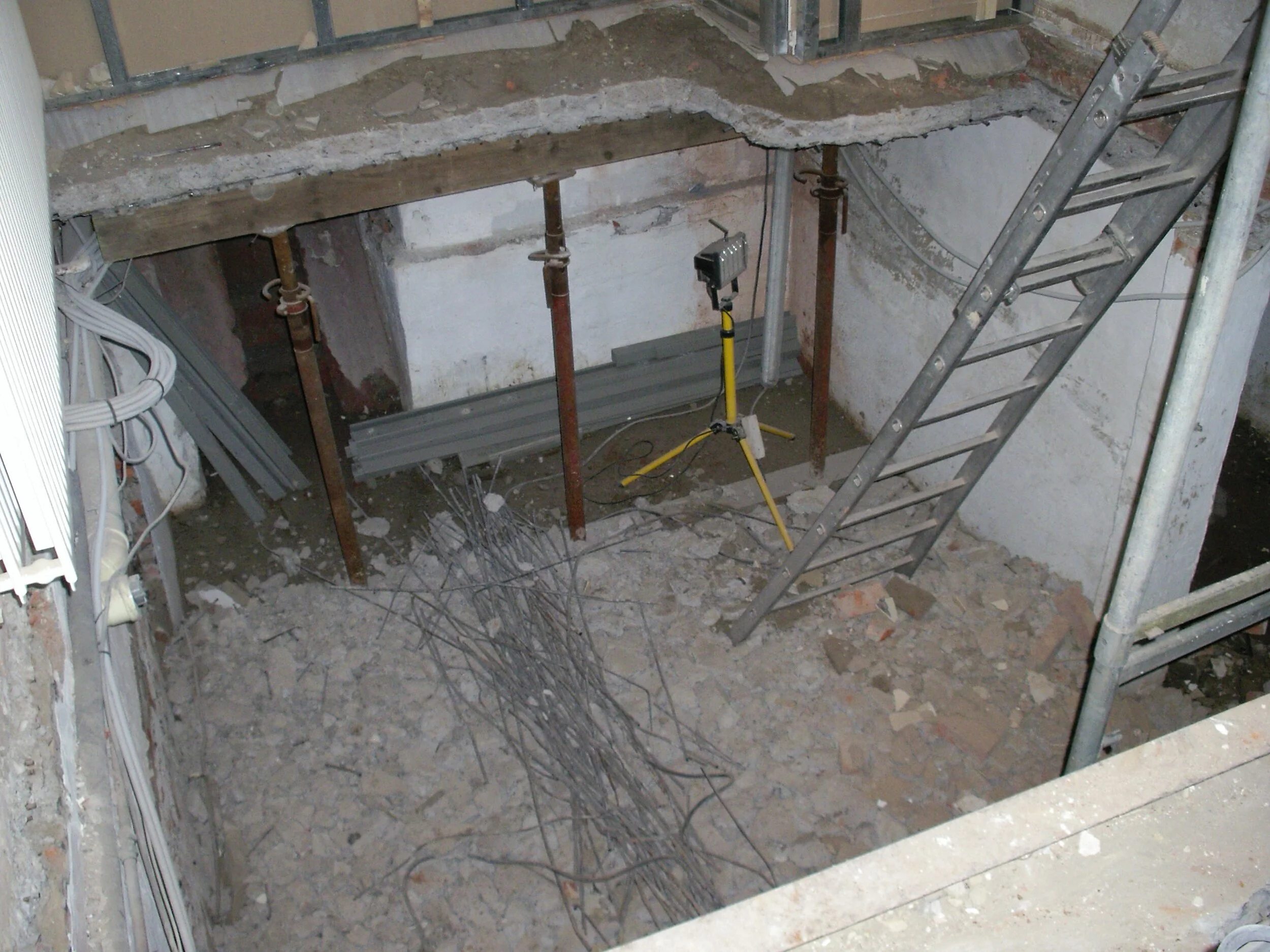 Verwijderen van bestaande betonnen vloer boven kelderverdieping. Vloer was onvoldoende sterk & niet geïsoleerd