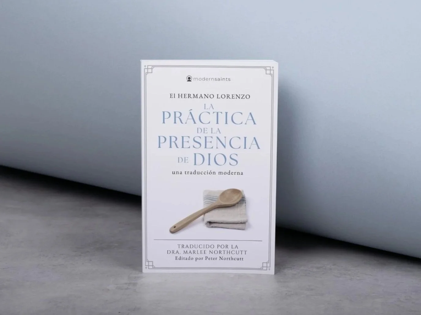 Book titled 'La Práctica de la Presencia de Dios' by El Hermano Lorenzo, with a subtitle indicating a modern translation, translated by Dr. Marlee Northcutt and edited by Peter Northcutt, with a small image of a spoon and stacked stones.