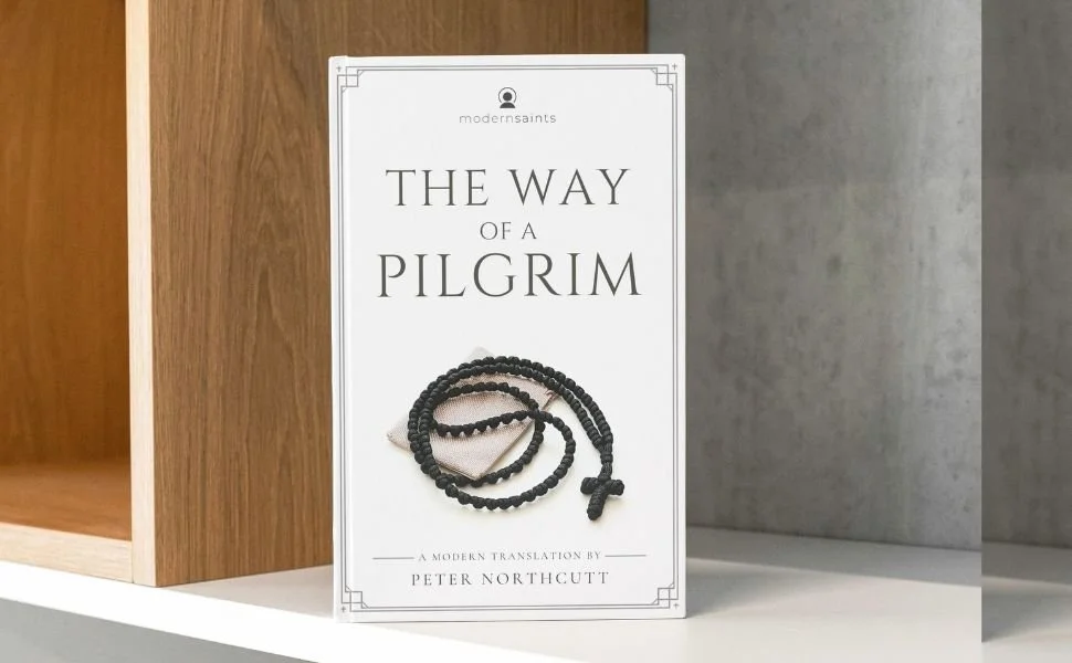 Book titled 'The Way of a Pilgrim' on a shelf, with a prayer rope in front.