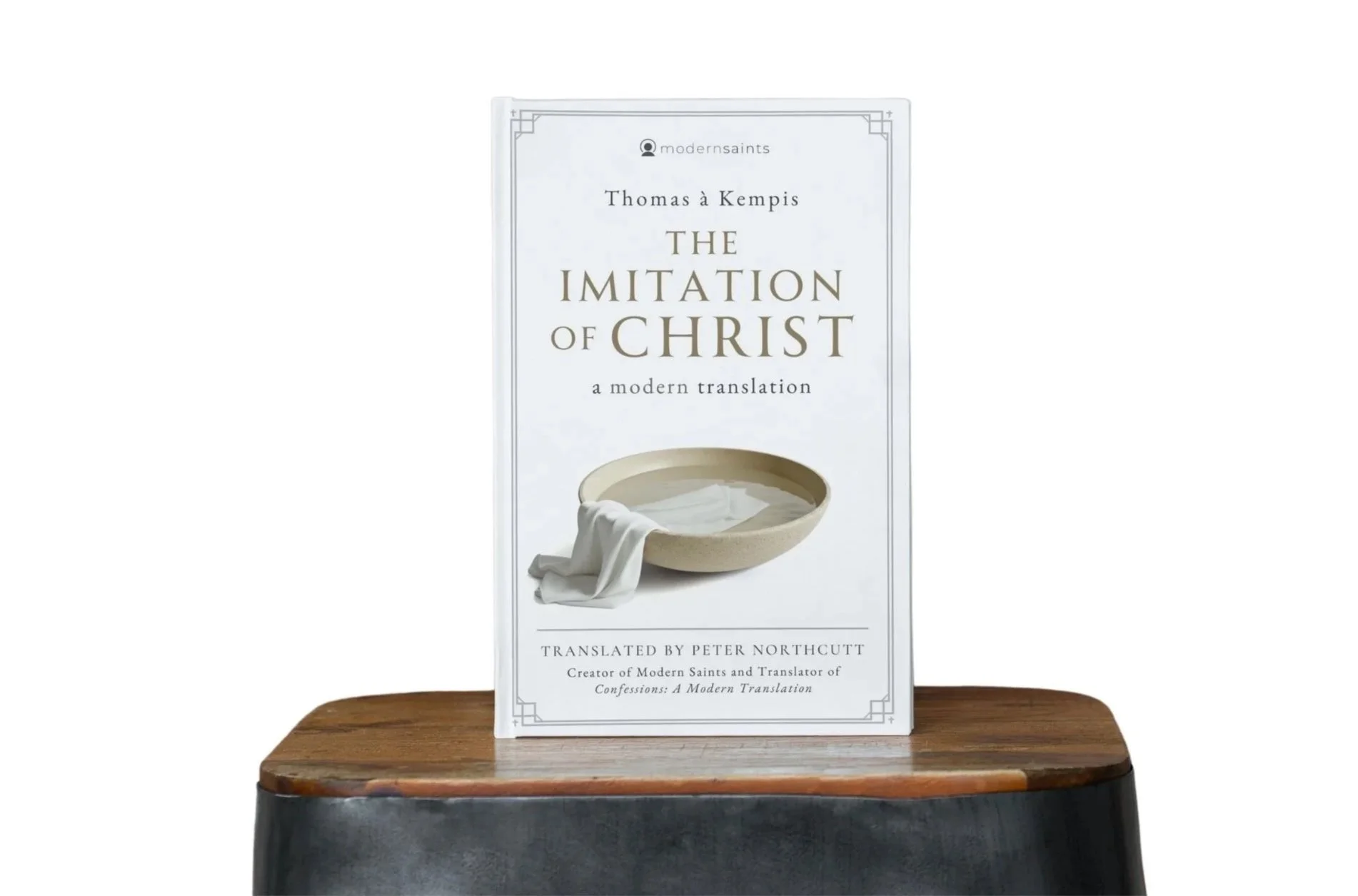 Book titled 'The Imitation of Christ' by Thomas à Kempis, displayed on a wooden surface.
