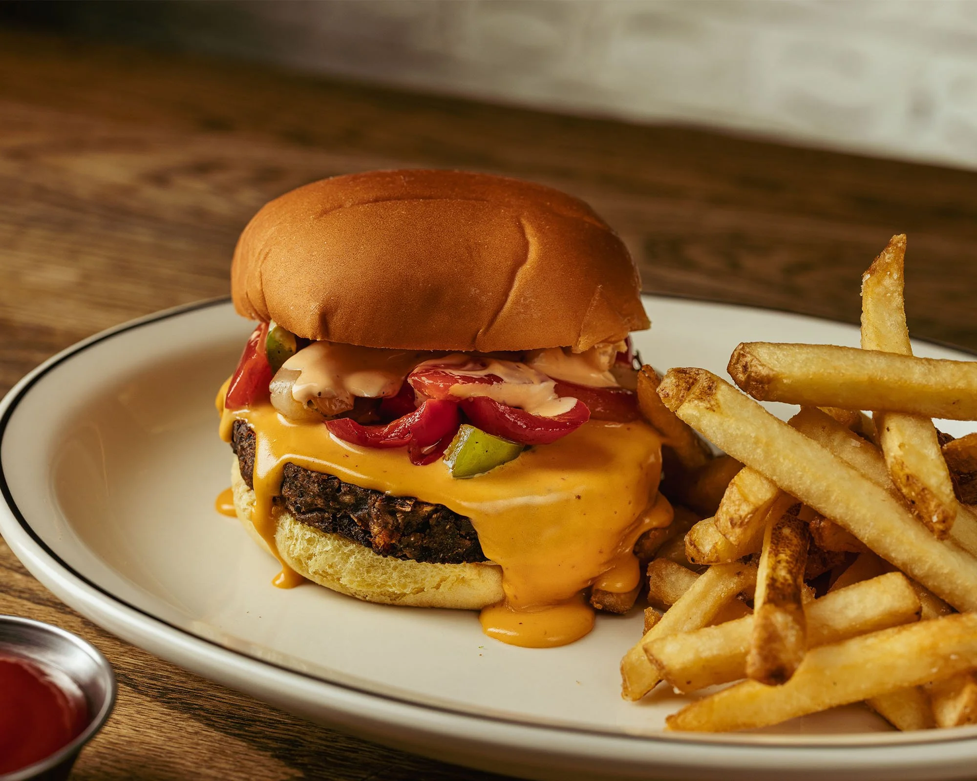 Fajita Veggie Burger with fries on a plate on a wooden table at Amity Hall Uptown on the Upper West Side