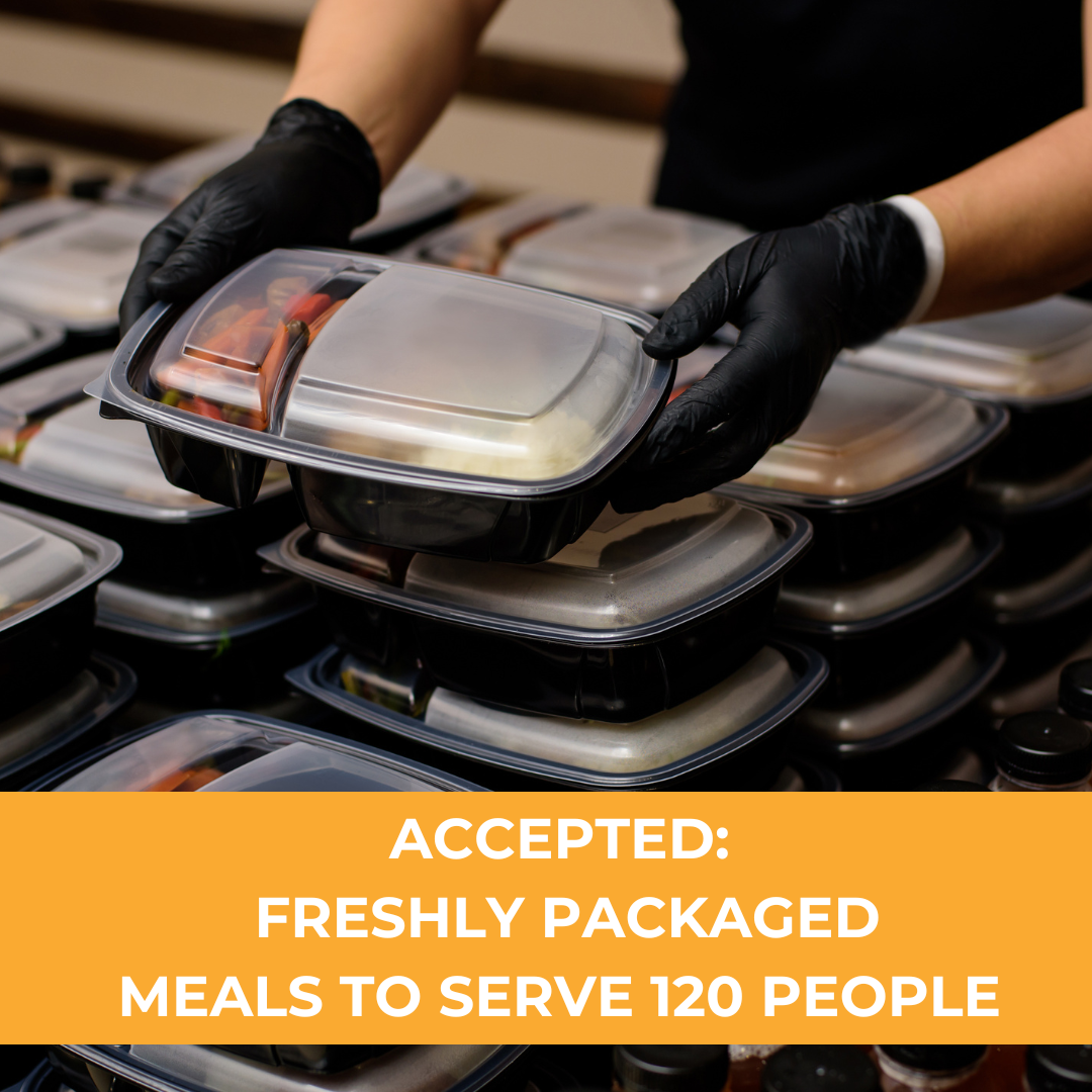 Stacks of black meal prep containers with transparent lids, some being filled or organized, and a person wearing black gloves handling a container for serving.