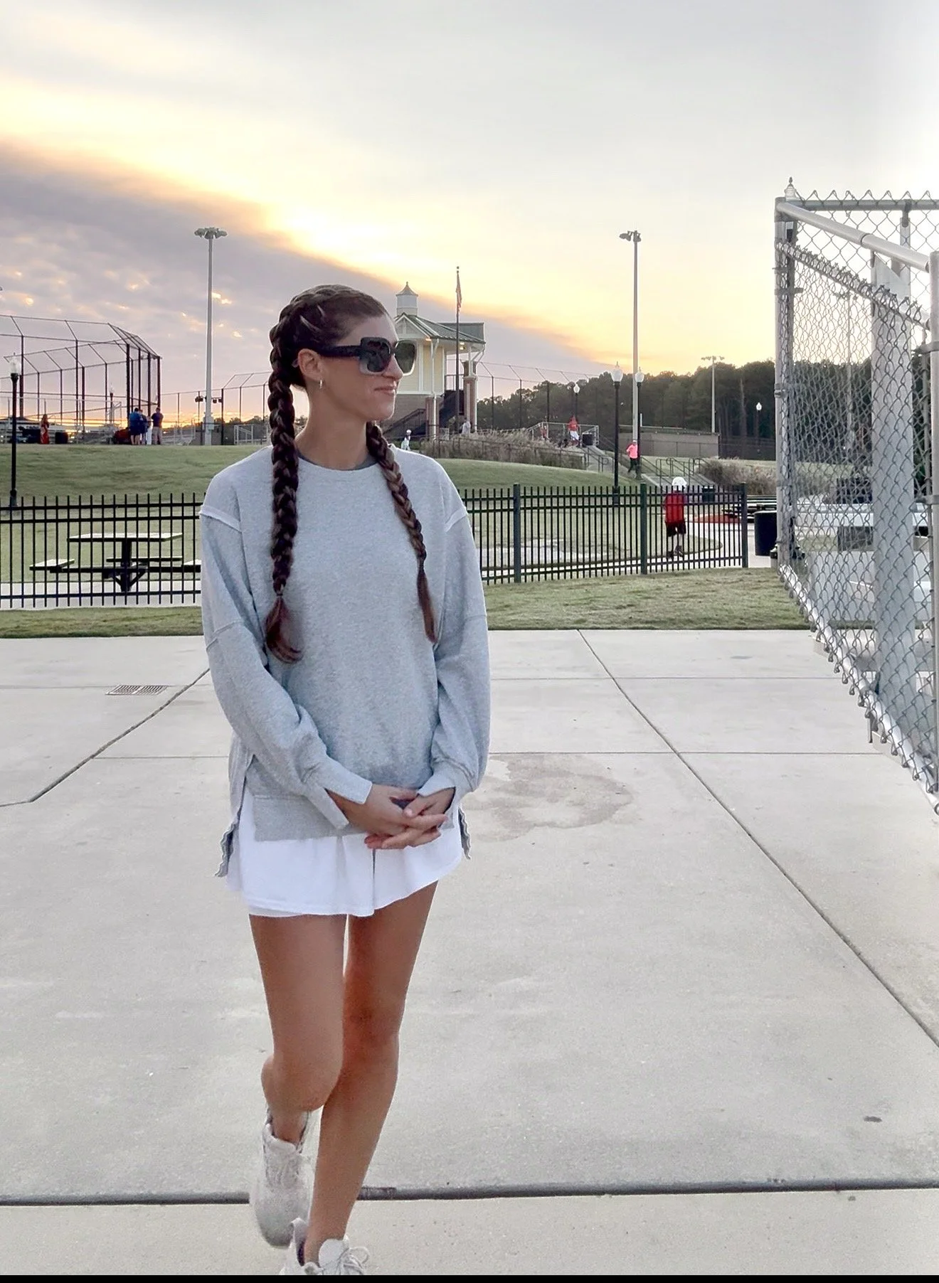 37-year-old mom standing at a baseball field at sunset reflecting on motherhood and personal growth