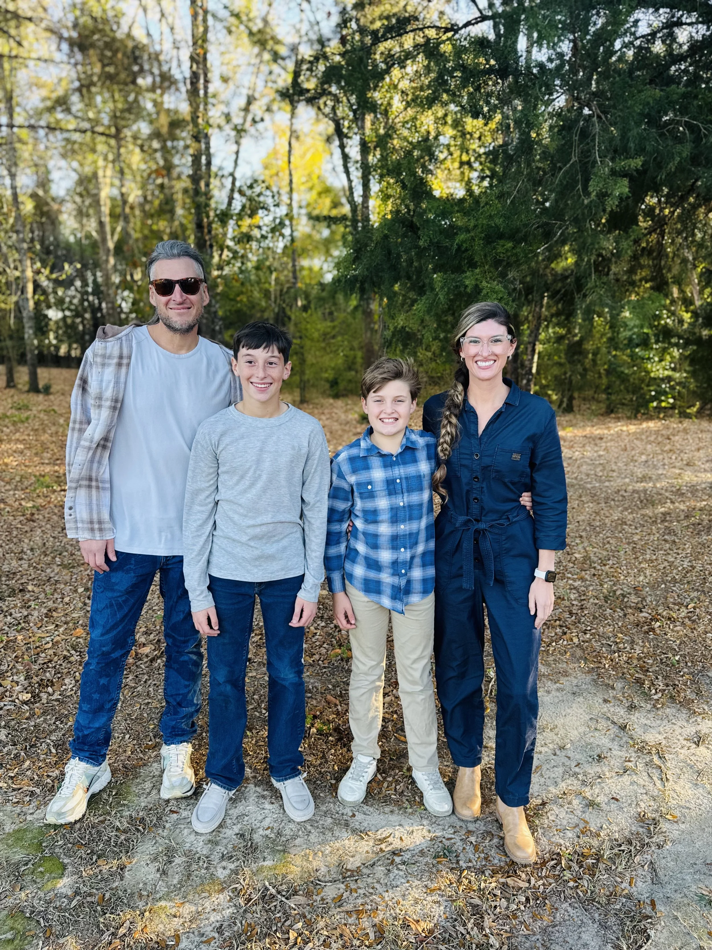 Mallory, author of Mom of War, with her husband and two sons outdoors