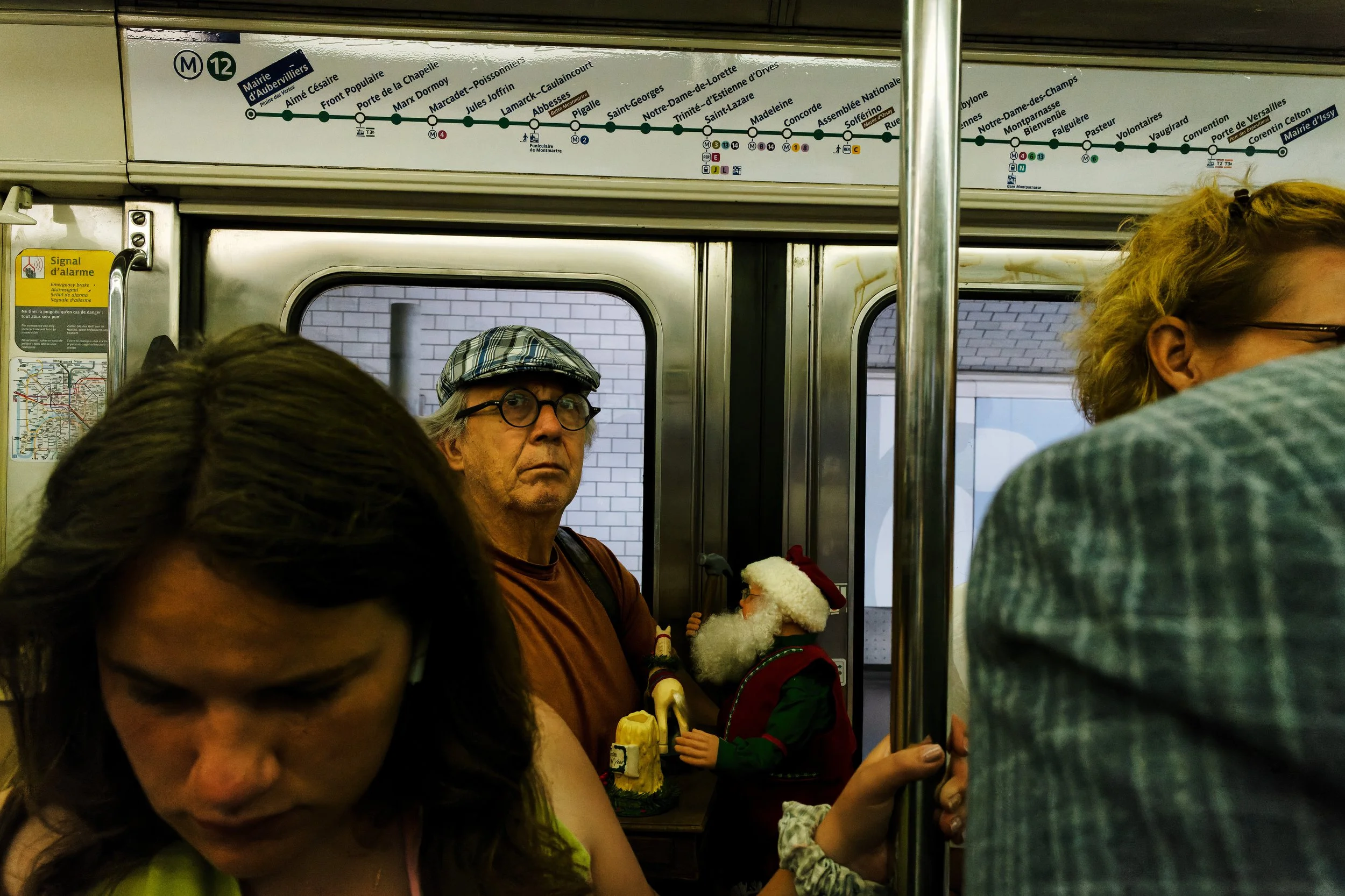 Another Passenger

Amid the compressed bodies of a Paris Metro carriage, an unexpected passenger appears beside a watchful traveler. Beneath the Line 12 map, the ordinary journey briefly slips into something humorous and slightly unreal.