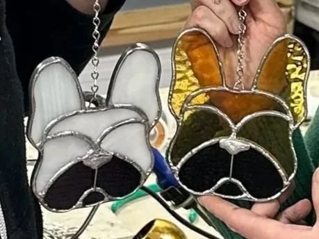 two french bulldog sun catchers made with the copper foil stained glass process, one in tans and one in whites. this is a premium stained glass project for beginners at stern glass works